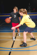 Two female basketball players compete in gym
