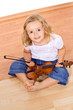 Little girl sitting on the floor with a violin