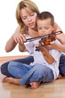 Little boy practicing the violin  with a woman