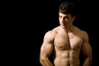 Portrait of handsome muscular man on black background