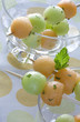 Two serving plates with melon salad garnished with skewers