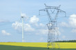 A electric pylon near windturbine over rape field France A electric pylon near windturbine over rape field France