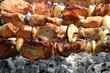 Pieces of pork shish kebab on skewers above ashes Pieces of pork shish kebab on skewers above ashes