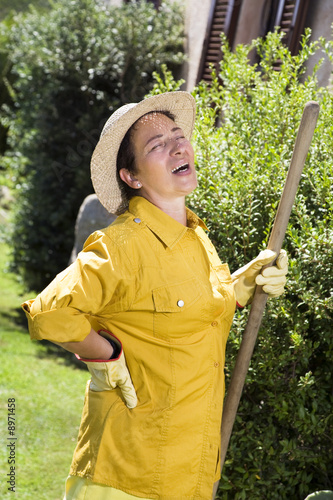 Photo: Tired senior Italian woman having backache while gardening Tired senior Italian woman having backache while gardening