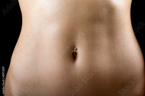 Photo: a sexy tummy of the young woman. Isolated on black a sexy tummy of the young woman. Isolated on black