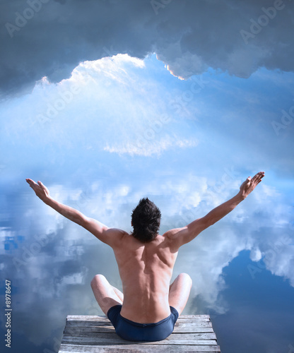 A man is sitting with his hands raised in the air