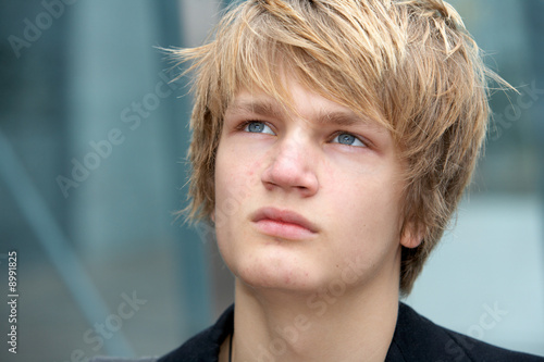 Photo: Pensive teenage boy in urban environment, close-up Pensive teenage boy in urban environment, close-up