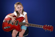 little girl playing with red electric guitar and singing