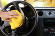 Foto: Woman's hand with microfiber cloth polishing steering wheel Woman's hand with microfiber cloth polishing steering wheel