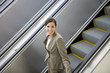 Businesswoman riding on escalator