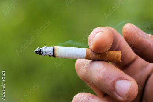 Foto: cigarette en main, fond vert cigarette en main, fond vert