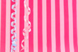 pink striped background with colorful ribbons hanging