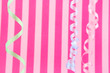 pink striped background with colorful ribbons hanging
