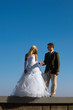 Photo: Bride and fiance on blue sky background Bride and fiance on blue sky background