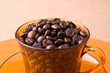 Coffee beans in an orange cup Coffee beans in an orange cup