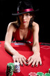 Attractive woman playing poker at a red poker table wearing Attractive woman playing poker at a red poker table wearing