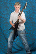 A young guitar player on a blue background playing the guitar