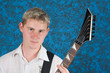 A young guitar player closeup portrait on a blue background