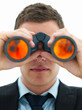 Closeup of young business man looking through binoculars Closeup of young business man looking through binoculars