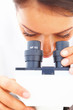 Closeup of a young girl looking into a microscope