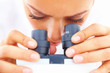 Closeup of a young lady looking into a microscope