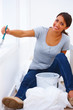 Portrait of a beautiful happy girl sitting painting a white wall