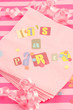 cut out letters spelling it's a party on pink napkins