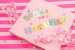 cut out letters spelling you're invited on pink napkins