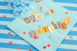 cut out letters spelling you're invited on baby blue napkins