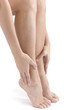 Woman rubbing her feet on white background .