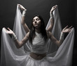 Two girls in white raiment dancing in semidarkness