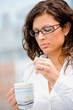 Young businesswoman drinking coffee and thinking.