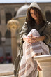 Girl in hoot is sitting on the square