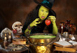 Photo: Green halloween witch putting a red apple in a cauldron Green halloween witch putting a red apple in a cauldron