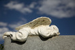 A sleeping angel adorns a granite headstone.