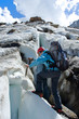 Girl with ice-axe climbing on mountain