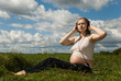 A pregnant woman listens to music