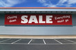 Retail building with a sign for a closing down sale.