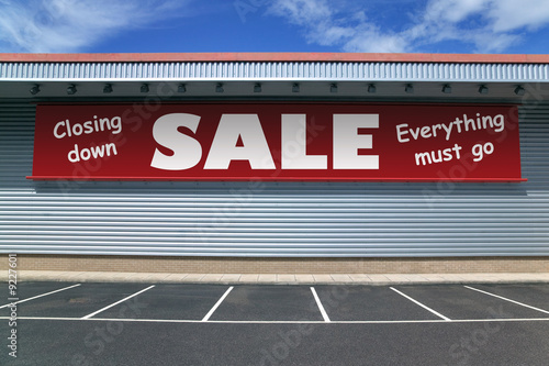 Retail building with a sign for a closing down sale.