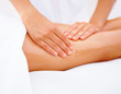 Foto: Closeup of a womans legs receiving massage on white Closeup of a womans legs receiving massage on white