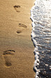Footprints on beach sand at sunset; vertical frame Footprints on beach sand at sunset; vertical frame