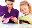 Closeup of happy young mother with her daughter cutting Closeup of happy young mother with her daughter cutting