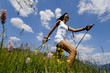 Young woman Nordic walking in meadow, Germany, low angle view
