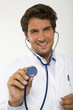 Male doctor holding stethoscope, close-up, portrait