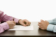 Businessmen sitting at conference table opposite each other, close-up