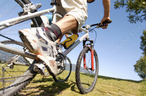 Photo: Young man riding mountain bike, low angle view, low section Young man riding mountain bike, low angle view, low section