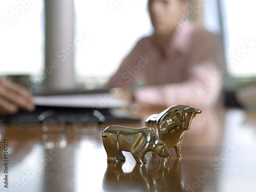 Photo: Figurines of bull and bear on desk Figurines of bull and bear on desk