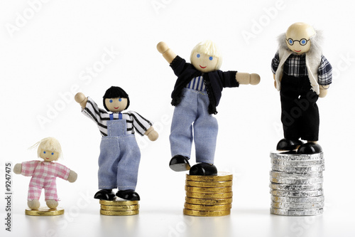 Photo: Figurines standing on piles of coins Figurines standing on piles of coins