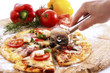 Man slicing pizza with wheel cutter