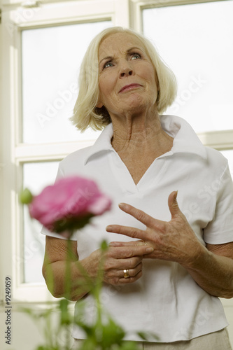 Foto: Senior woman standing, looking up, portrait Senior woman standing, looking up, portrait